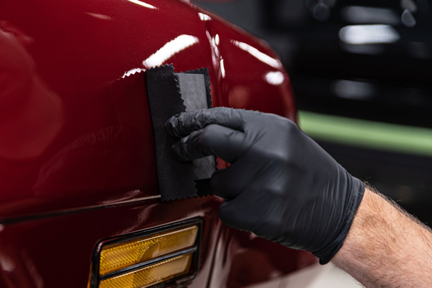 Car detailing man worker applying ceramic coating